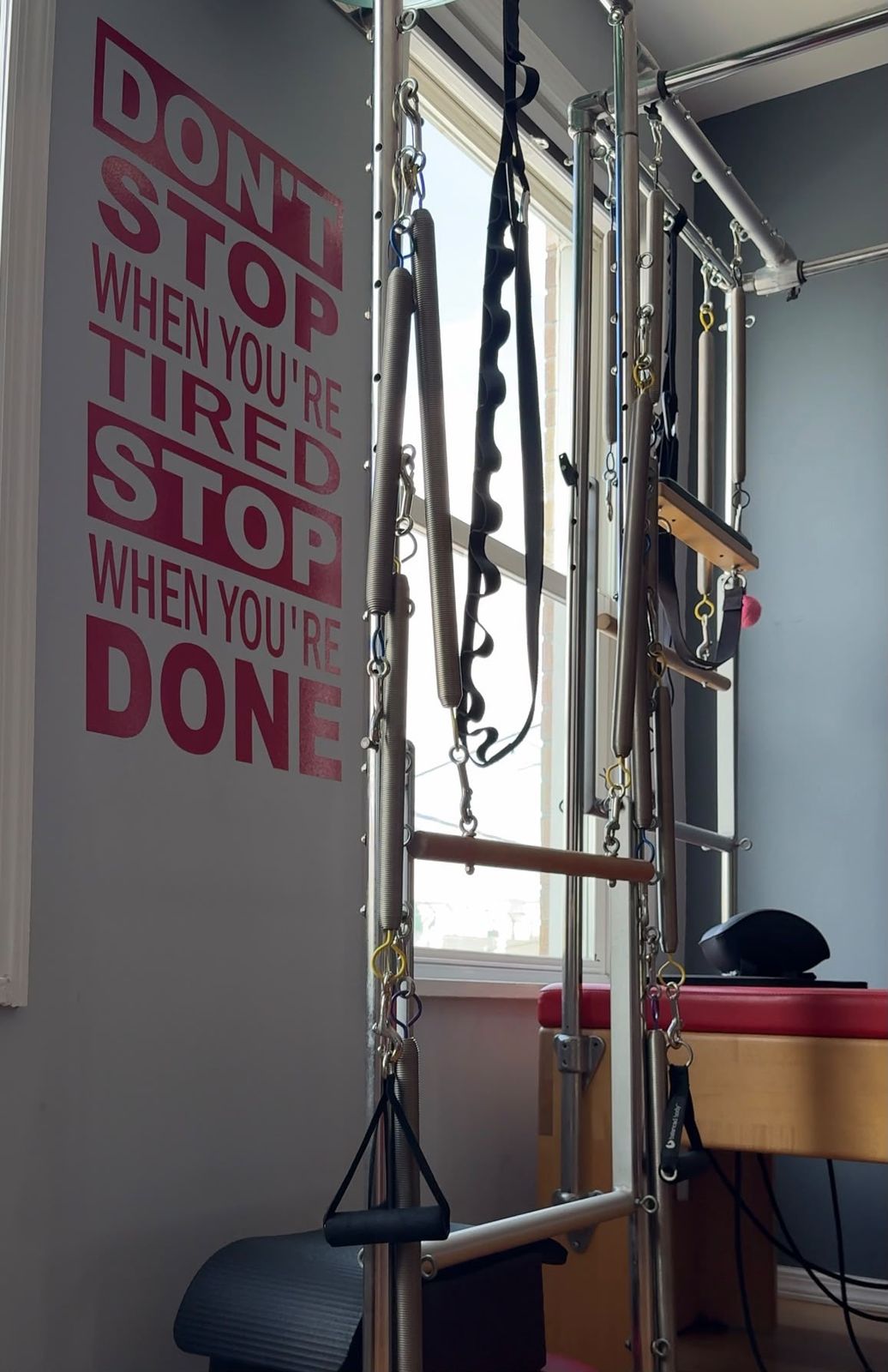 Pilates tower with a motivational wall quote